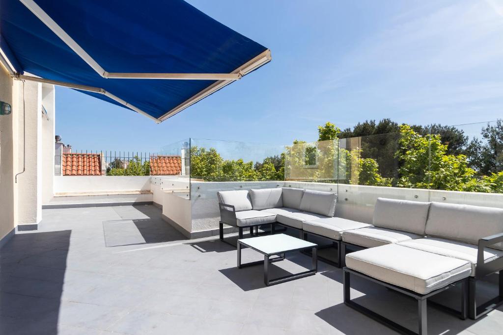 a patio with couches and tables on a roof at Cascais Duplex Apartment in Cascais