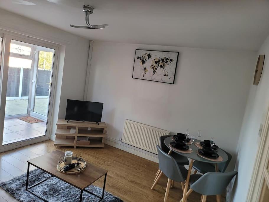 a living room with a table and chairs and a television at 2 Bedroom end of terrace house in Wellington