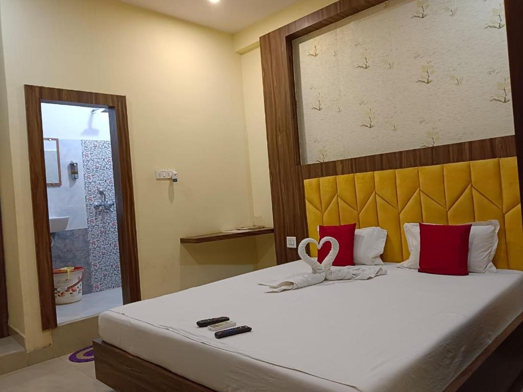 1 dormitorio con 1 cama grande con almohadas rojas y blancas en The A Cube Inn, en Bokāro
