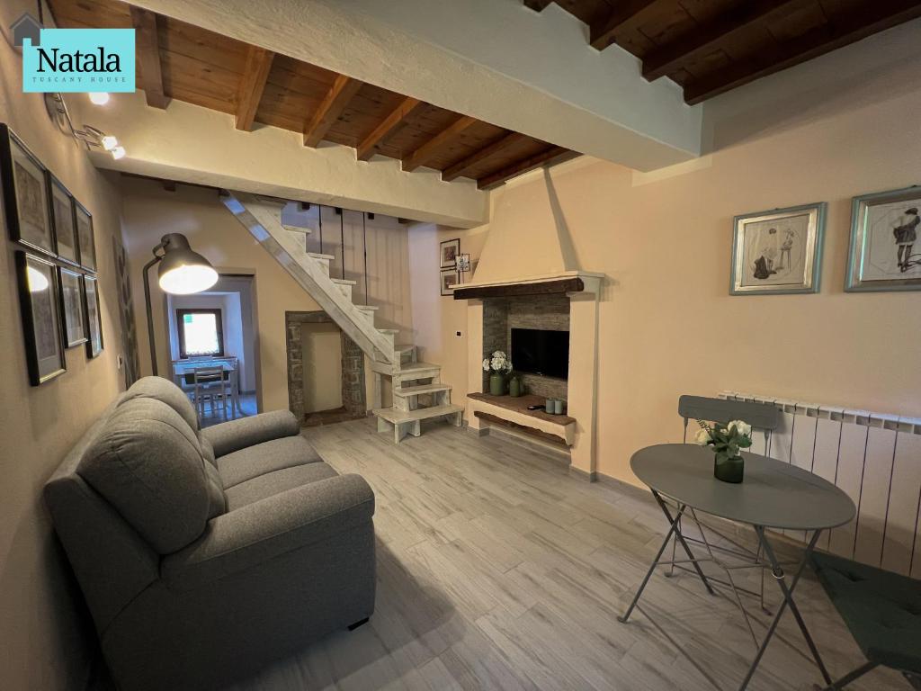 un soggiorno con divano e tavolo di Casa Natala a Bagni di Lucca