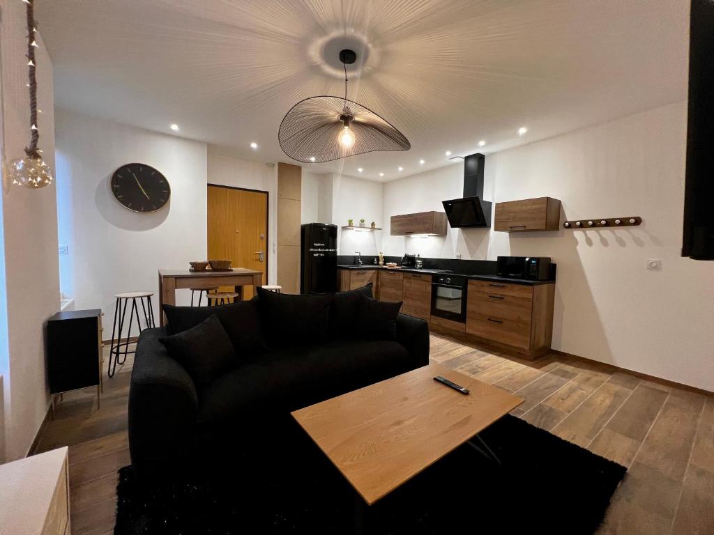 - un salon avec un canapé et une table dans l'établissement Appartement cosy centre ville, à Roanne