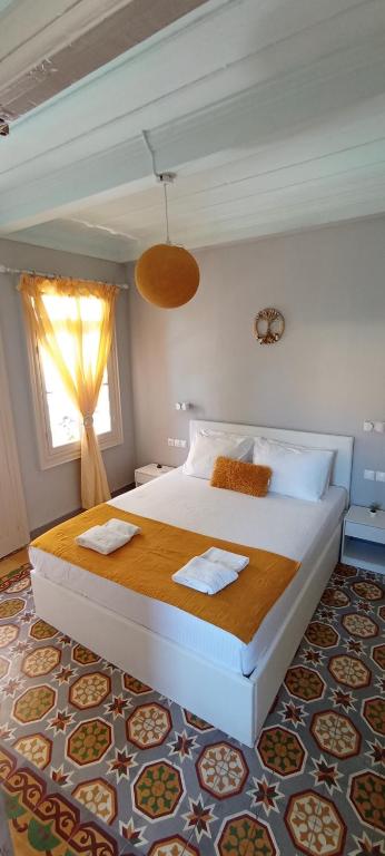 una camera da letto con un grande letto bianco e una finestra di Kosta n`tina Guest House a Città di Lefkada