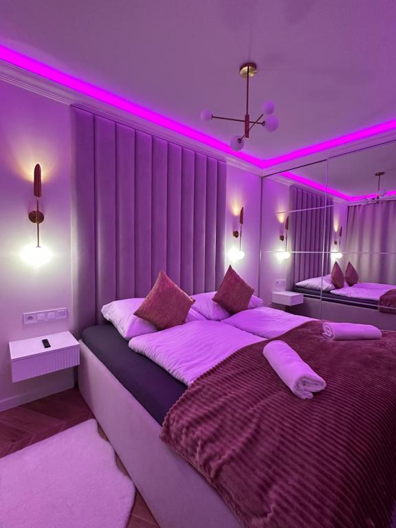 1 Schlafzimmer mit 2 Betten und rosafarbener Beleuchtung in der Unterkunft Apartments Ostsee Suntowers in Świnoujście