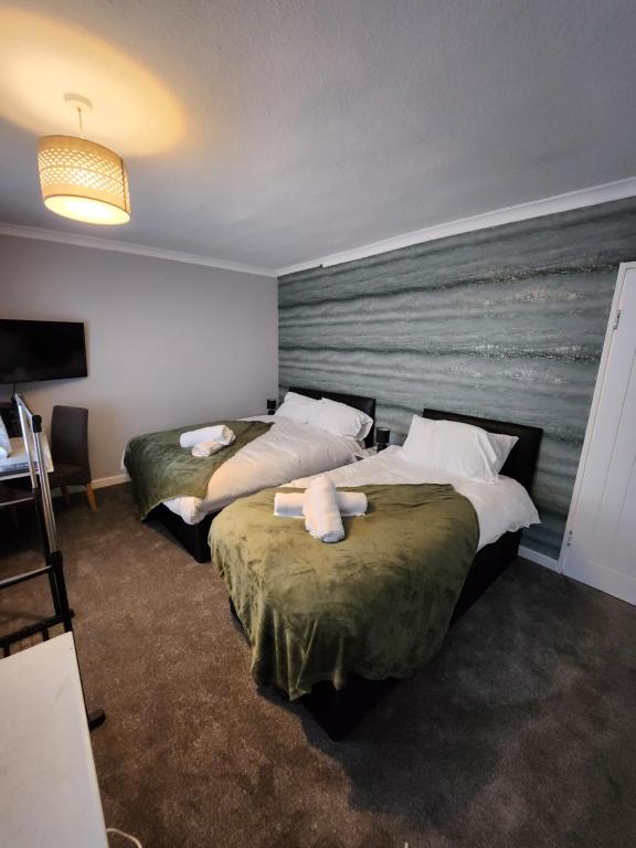 two beds in a hotel room with towels on them at Fox Hollies Shared House in Birmingham