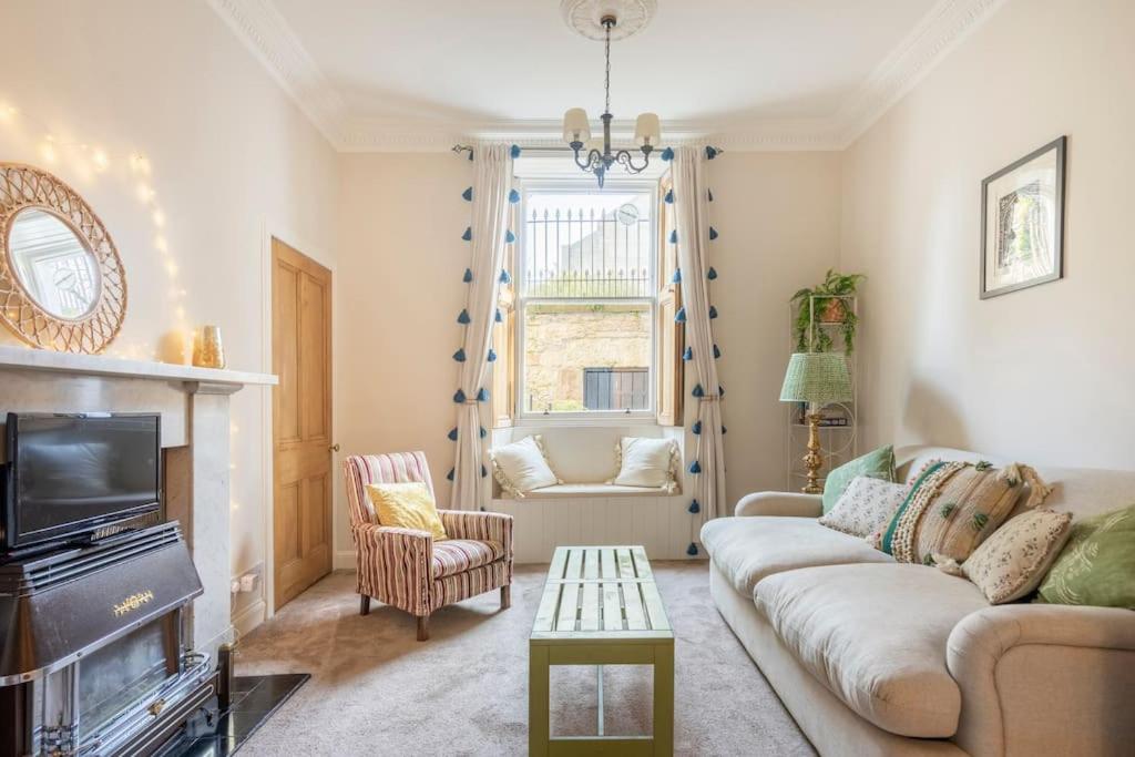 a living room with a couch and a tv at Charming flat in quiet street in Stockbridge in Edinburgh