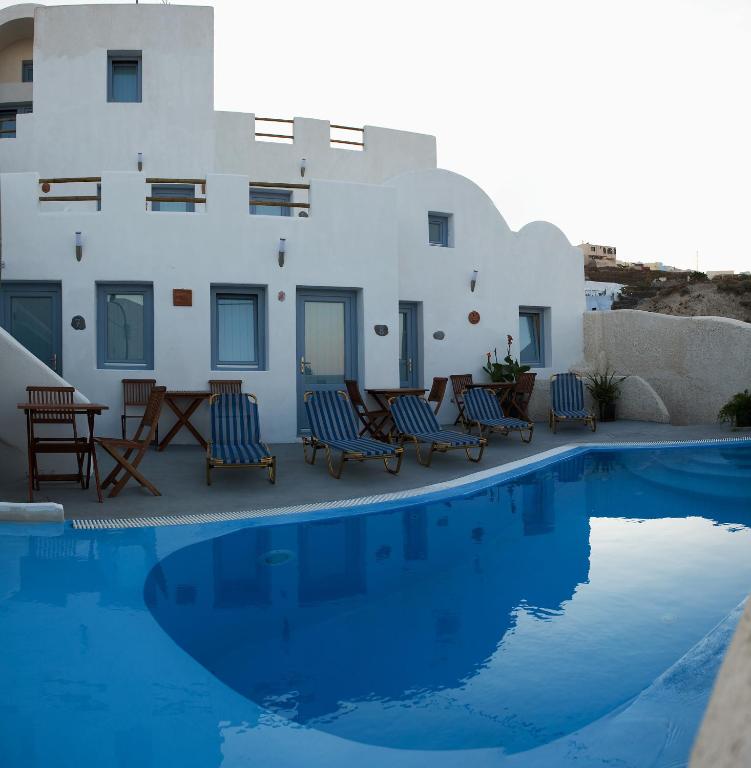 a villa with a swimming pool in front of a house at Villa Murano in Fira