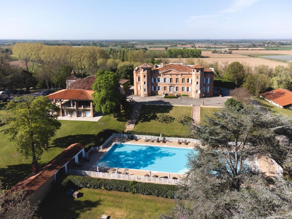 an aerial view of a large house with a swimming pool at Château de Loubéjac in Montauban