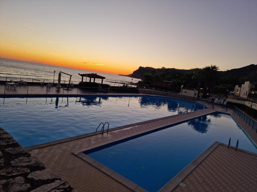 una gran piscina junto al océano al atardecer en Villa Giorgia Cilento, en Montecorice