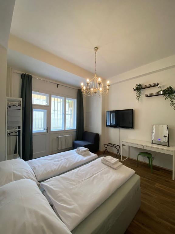 1 Schlafzimmer mit 2 großen weißen Betten und einem Kronleuchter in der Unterkunft Prahabel - C10 in Prag