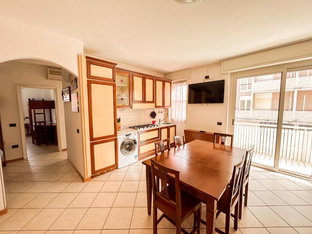 a kitchen and dining room with a wooden table at 7 posti nel cuore dell'area pedonale con parcheggio in Bibione