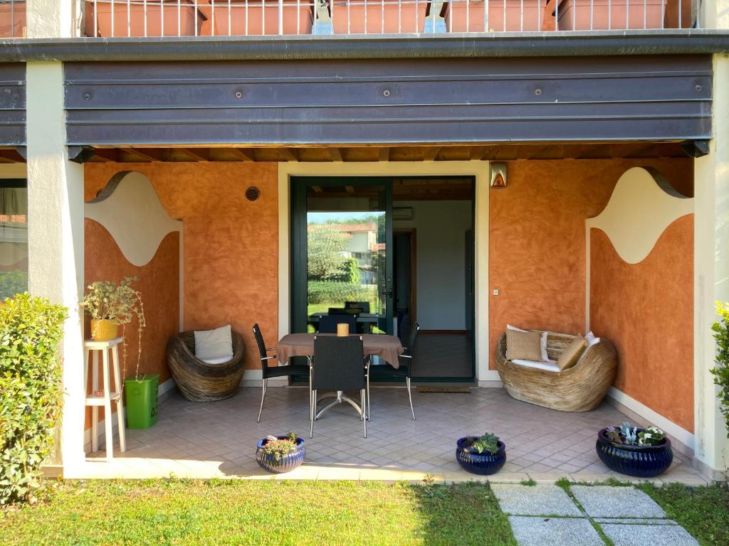 eine Terrasse mit einem Tisch und Stühlen darauf in der Unterkunft Casa degli Ulivi in Padenghe sul Garda