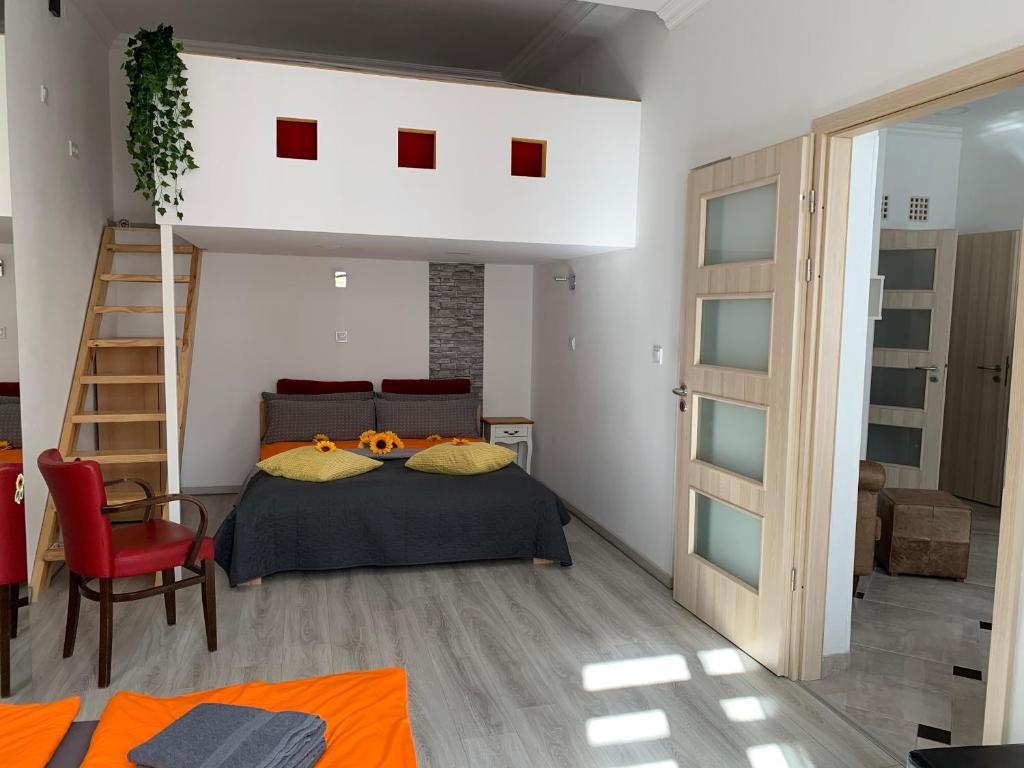 布達佩斯的住宿－Sunflowers Apartman，一间卧室配有一张床和梯子,另一间卧室配有橙色