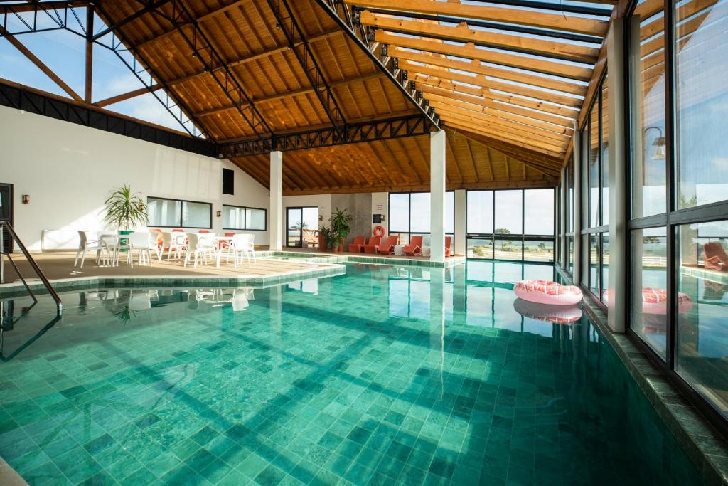 a large swimming pool with a large ceiling at Cerro Azul Hotel Fazenda in Capão Alto