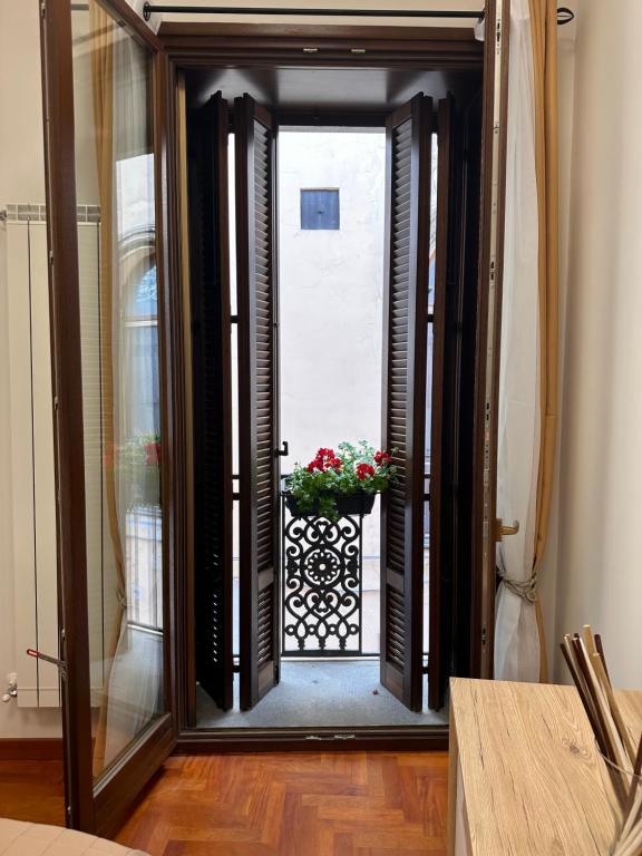 an open door with a flower pot on a balcony at Zara Palace - Tasso in Scafati