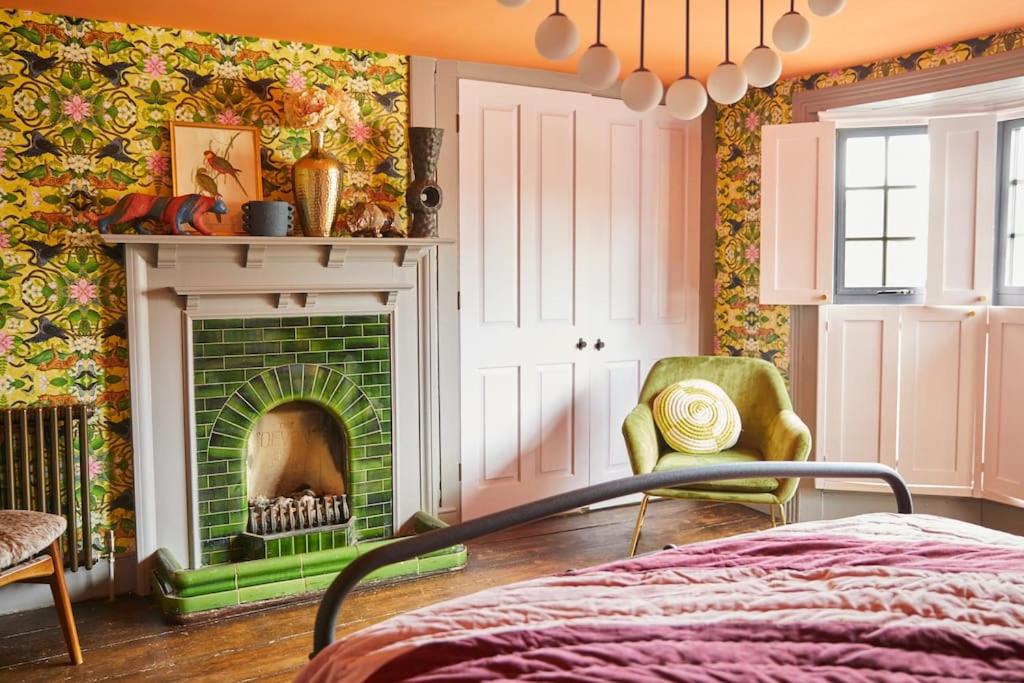 a bedroom with a fireplace and a bed at The Old Stout House - interior designed, converted 1700s Inn in Rye