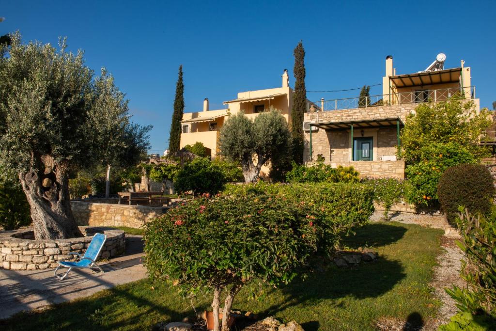 une maison avec une chaise bleue dans une cour dans l'établissement Sivas Apartments-Studios,Sigelakis with very nice view, à Sívas