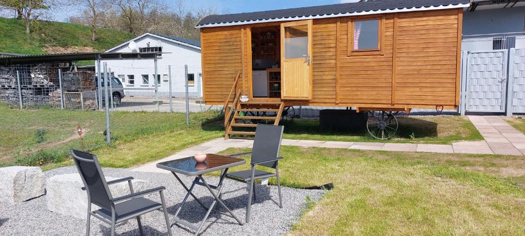 a tiny house with a table and chairs at Urlaub im Bauwagen in Mörlenbach