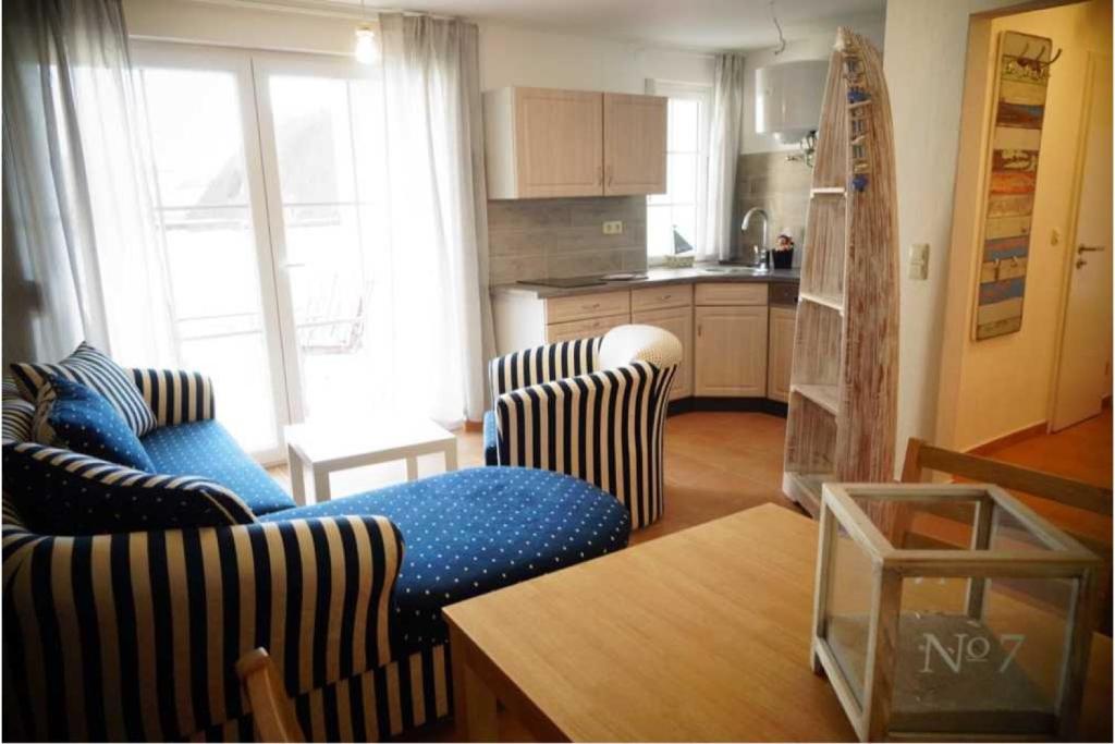 ein Wohnzimmer mit 2 Sofas und einer Küche in der Unterkunft Dorfstrasse34b Großer Bungalow in Ostseebad Kölpinsee