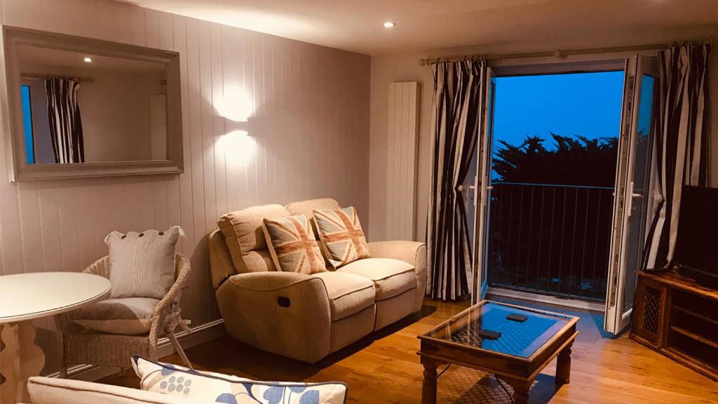 a living room with a couch and a table at Chesil Beach Lodge Burton Bradstock Dorset DT64RJ in Bridport