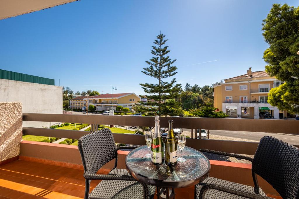 a patio table with chairs and a tree on a balcony at Hotel Colmeia in Monte Real