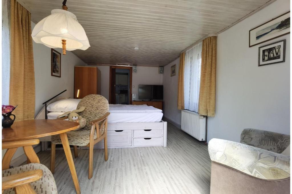 a bedroom with a bed and a desk and a table at Ferienwohnung Hasenlodde in Loddin