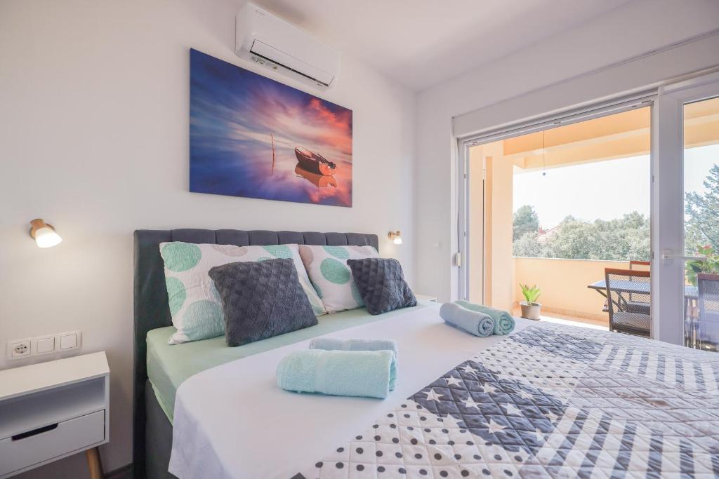 a bedroom with a large bed and a balcony at Apartment Bojana in Petrcane