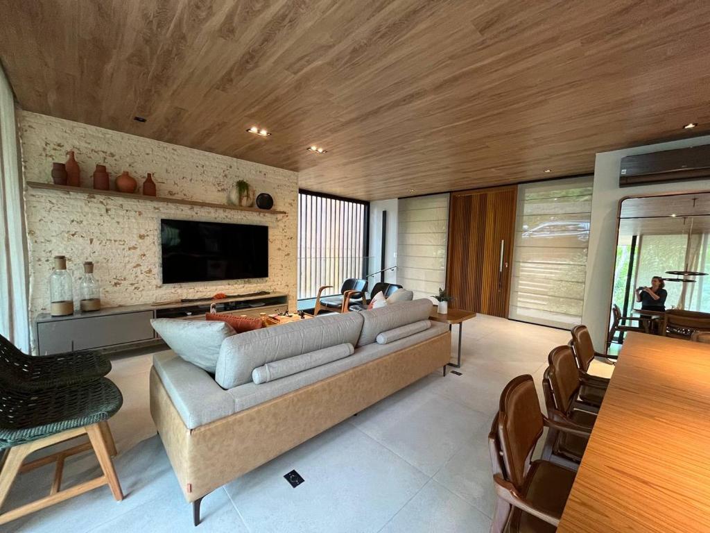 sala de estar con sofá y TV en Casa 13 da Villa - Fazenda Marambaia, en Petrópolis