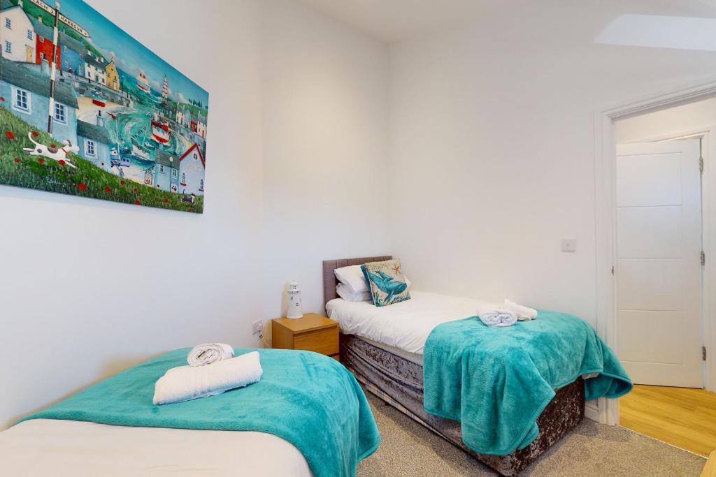 a bedroom with two beds and a painting on the wall at Crabbers' Wharf in Portland