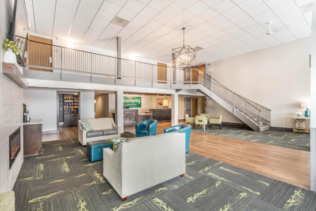 a living room with a couch and chairs and a staircase at EverSpring Inn and Suites in Marshall