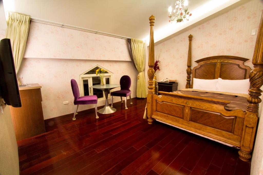 a bedroom with a bed and a table and chairs at Formosa Vacation Village Homestay in Ren&#39;ai