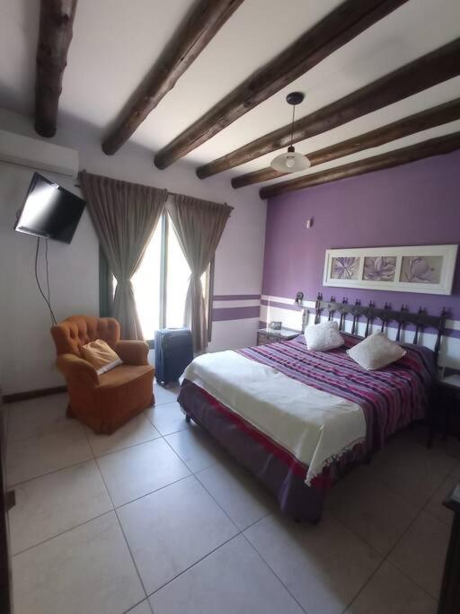 a bedroom with a bed and a chair at La Josefina. in Maipú