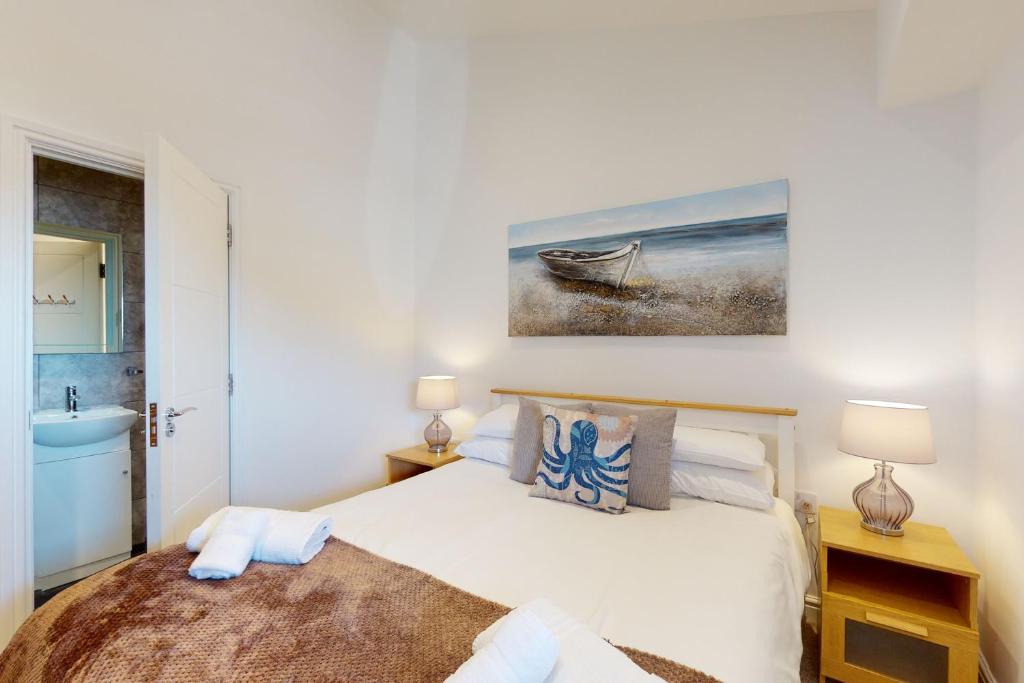 a white bedroom with a bed and a sink at Crabbers' Wharf in Portland
