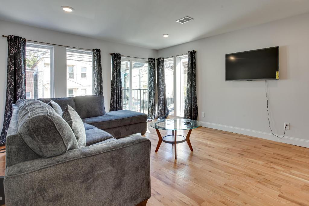 a living room with a couch and a flat screen tv at Stylish Newark, New Jersey, Vacation Rental! in Newark