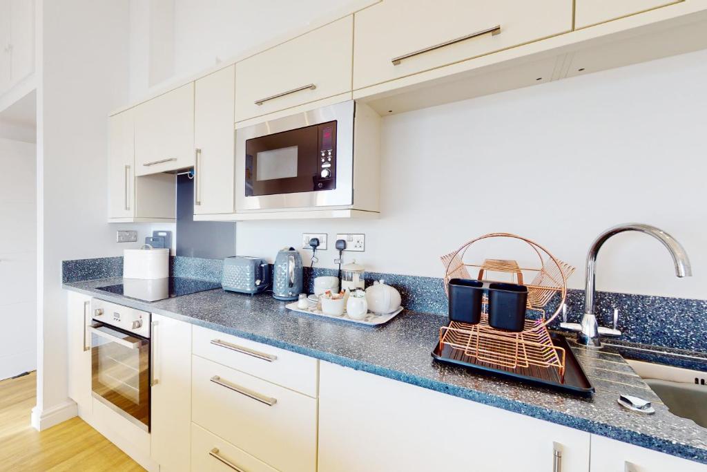 a kitchen with white cabinets and blue counter tops at Crabbers' Wharf in Portland