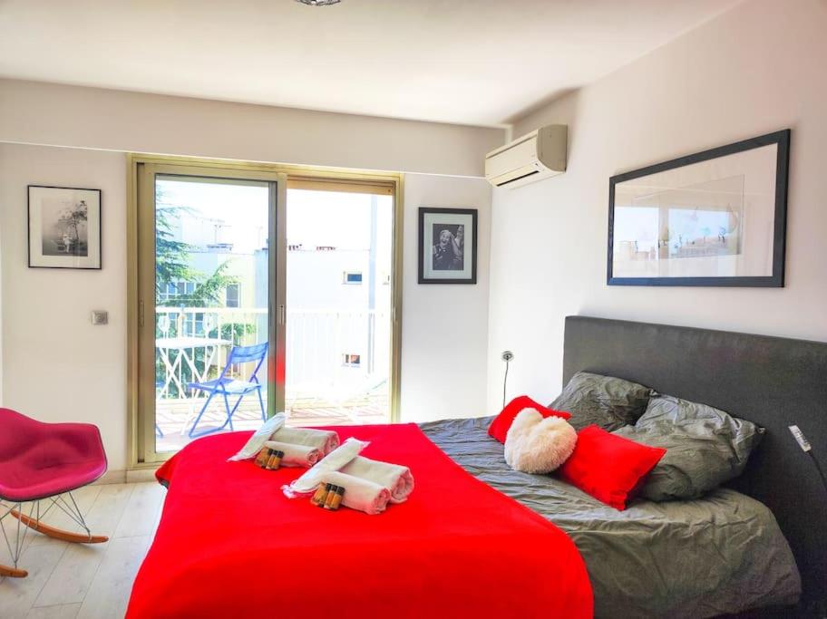 um quarto com uma cama vermelha e um cobertor vermelho em Le Regency YourHostHelper 4* em Antibes