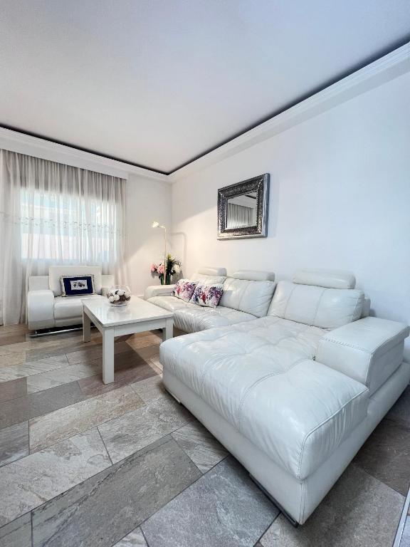 a living room with a white couch and a table at Espectacular Bajo Lirio in Calpe