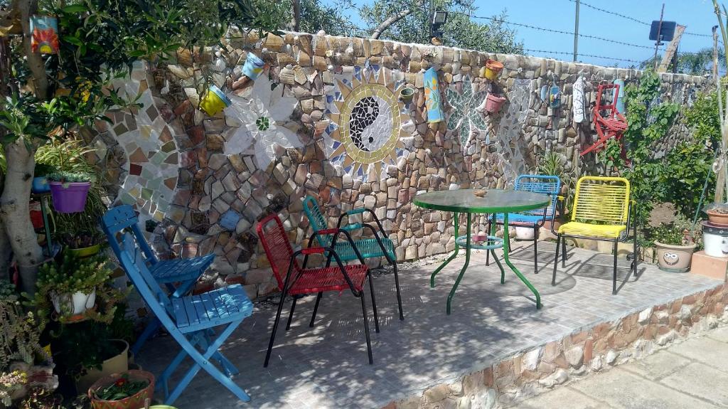 a wall with chairs and a table in front of a fence at Garden Fiorella in Cinisi