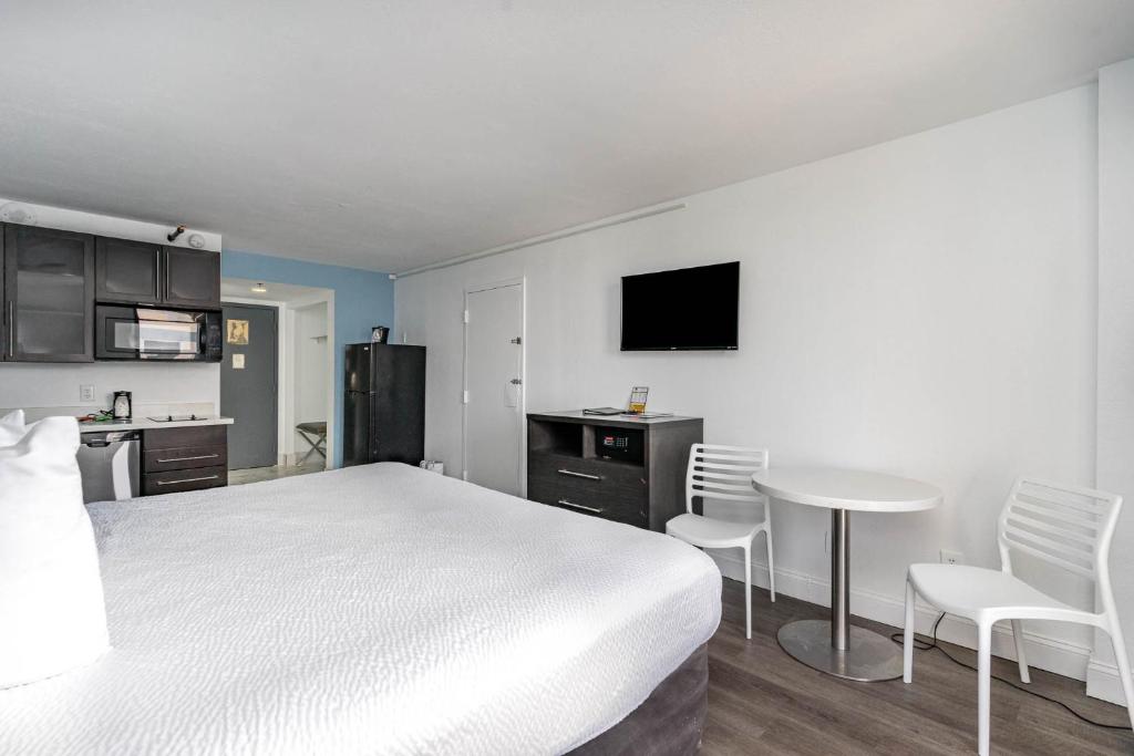 a bedroom with a white bed and a table and chairs at Sun N Sand Resort in Myrtle Beach