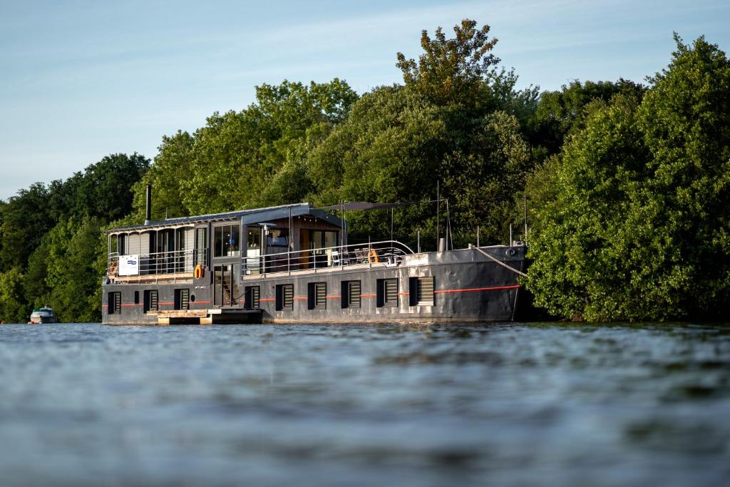 un bateau-maison au milieu de l'eau dans l'établissement La Rivière House - Péniche Carpe Diem, à Nantes