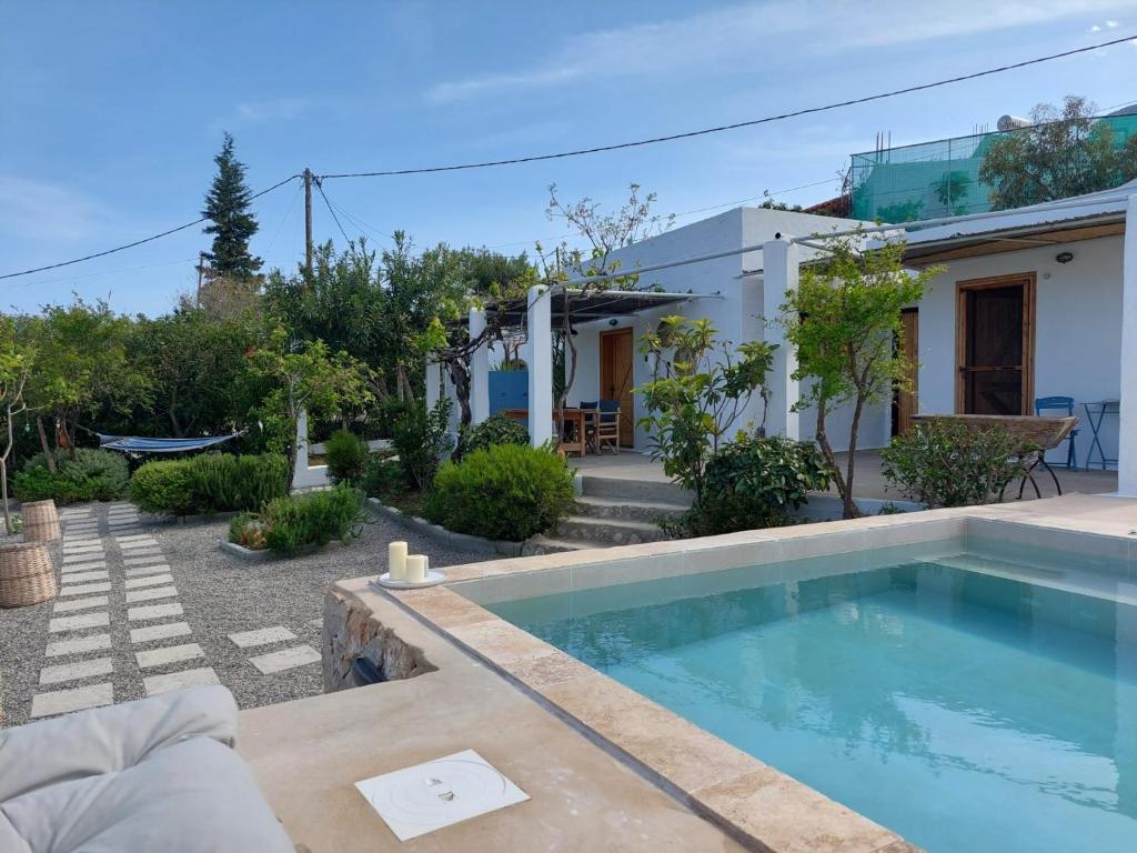 a villa with a swimming pool in front of a house at Ktima Natura in Archangelos