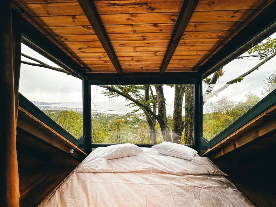里澤的住宿－Tepede Bir Işık Var! HillCabin，一张位于带大窗户的帐篷内的床铺