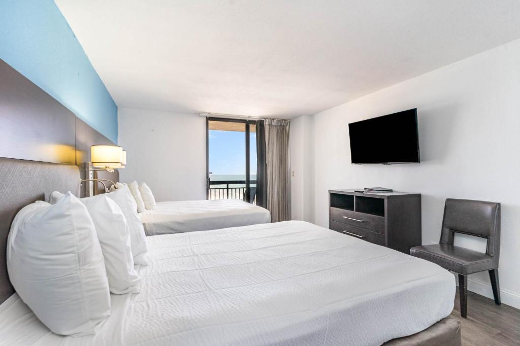 a hotel room with two beds and a television at Sun N Sand Resort in Myrtle Beach