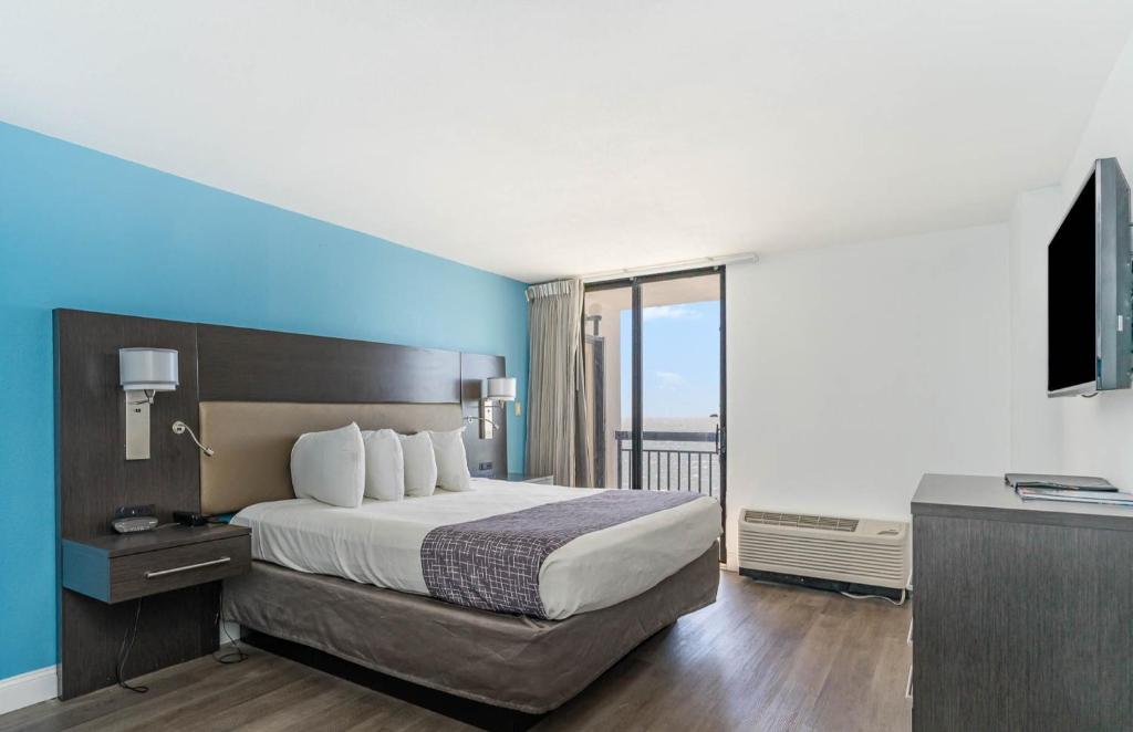 a hotel room with a bed and a balcony at Sun N Sand Resort in Myrtle Beach