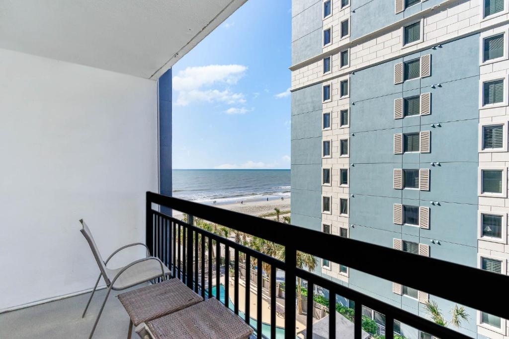 a balcony with a chair and a view of the beach at Sun N Sand Resort in Myrtle Beach