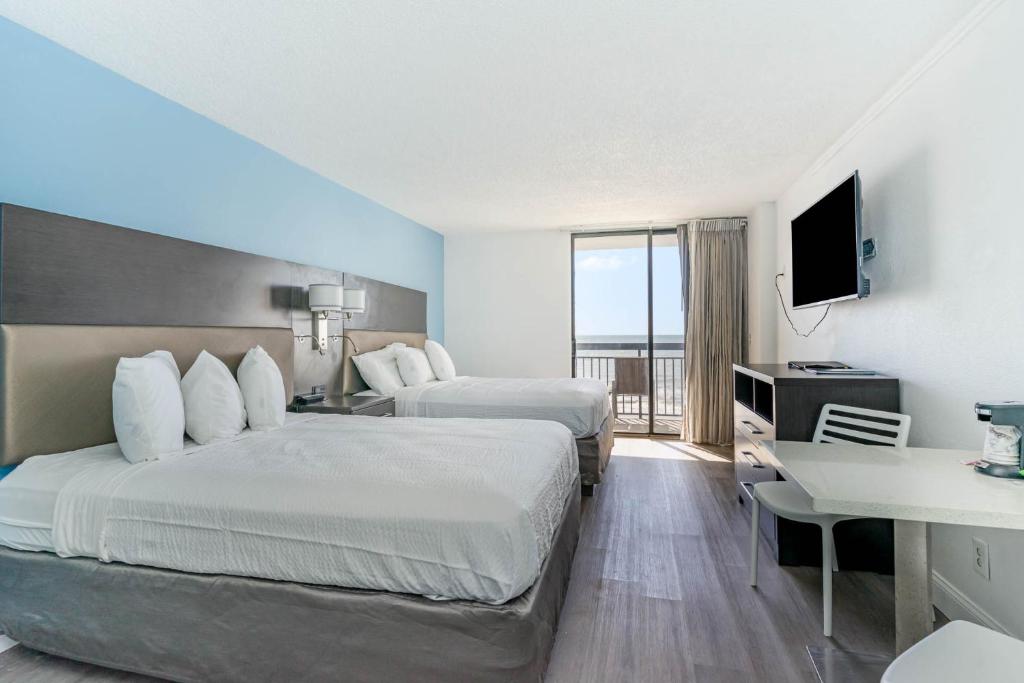 a hotel room with two beds and a television at Sun N Sand Resort in Myrtle Beach