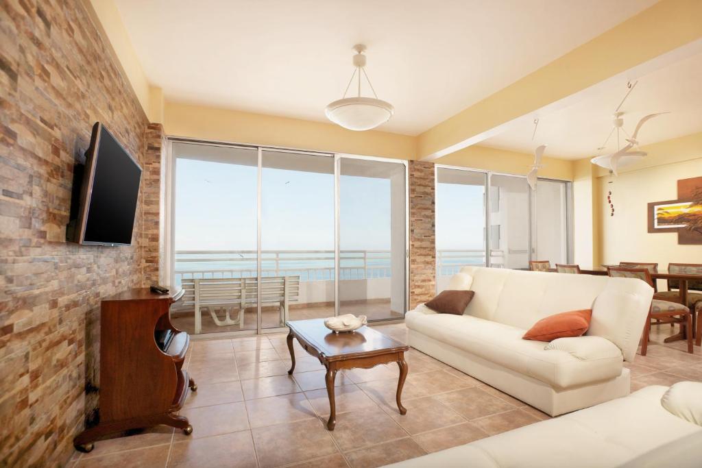 a living room with a couch and a tv at Condominio Carabelas de Colón in Playas
