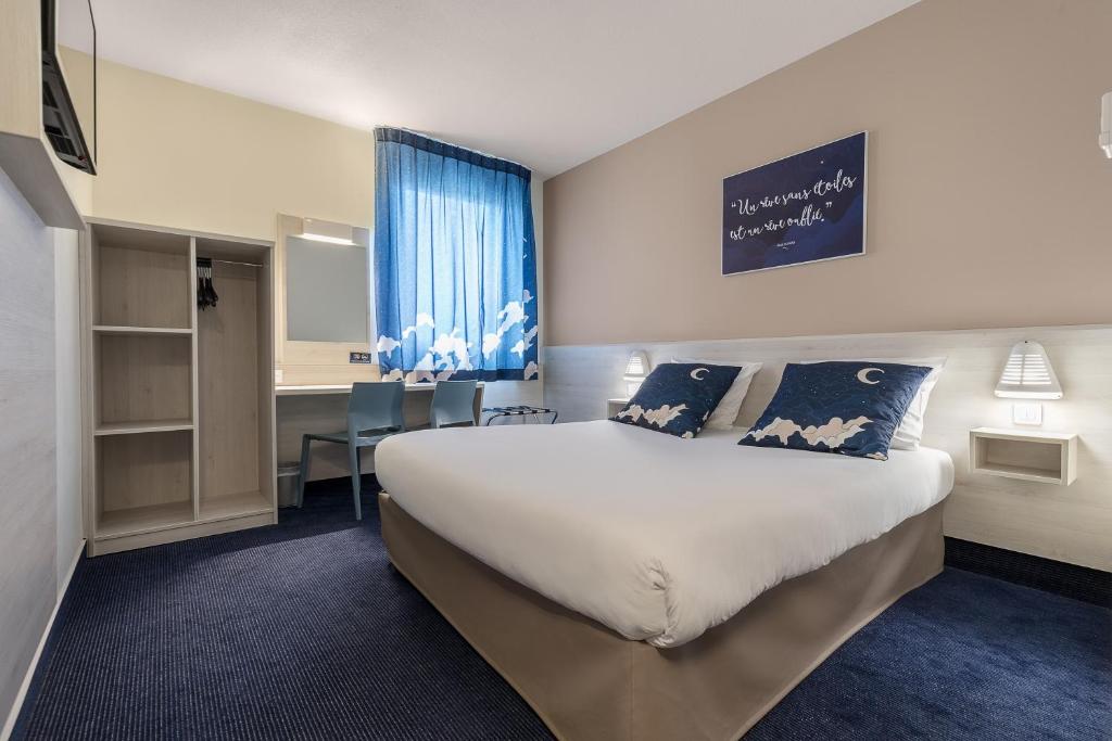 um quarto de hotel com uma cama grande e uma secretária em ACE Hôtel Metz em Metz