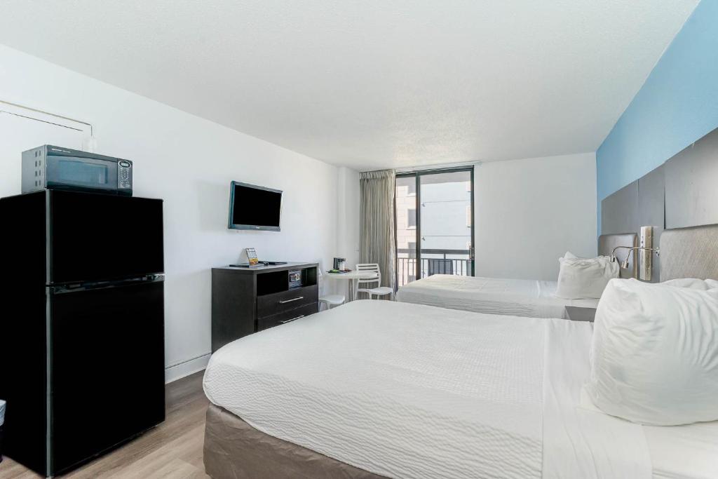 a hotel room with two beds and a television at Sun N Sand Resort in Myrtle Beach