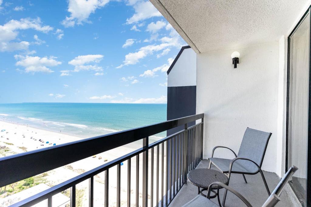 a balcony with two chairs and a view of the beach at Sun N Sand Resort in Myrtle Beach