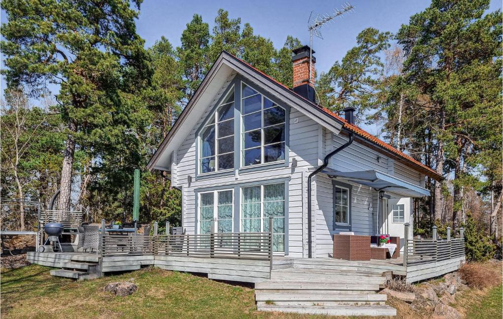Cette petite maison blanche dispose d'une grande fenêtre. dans l'établissement Amazing Home In Hllekis With Lake View, à Lugnås